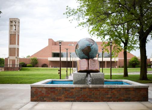 Bolivar campus forum with globe water sculpture in foreground and chapel in background